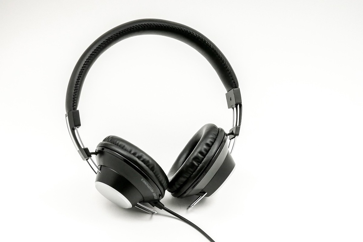 Casque audio noir posé sur fond blanc, câble visible