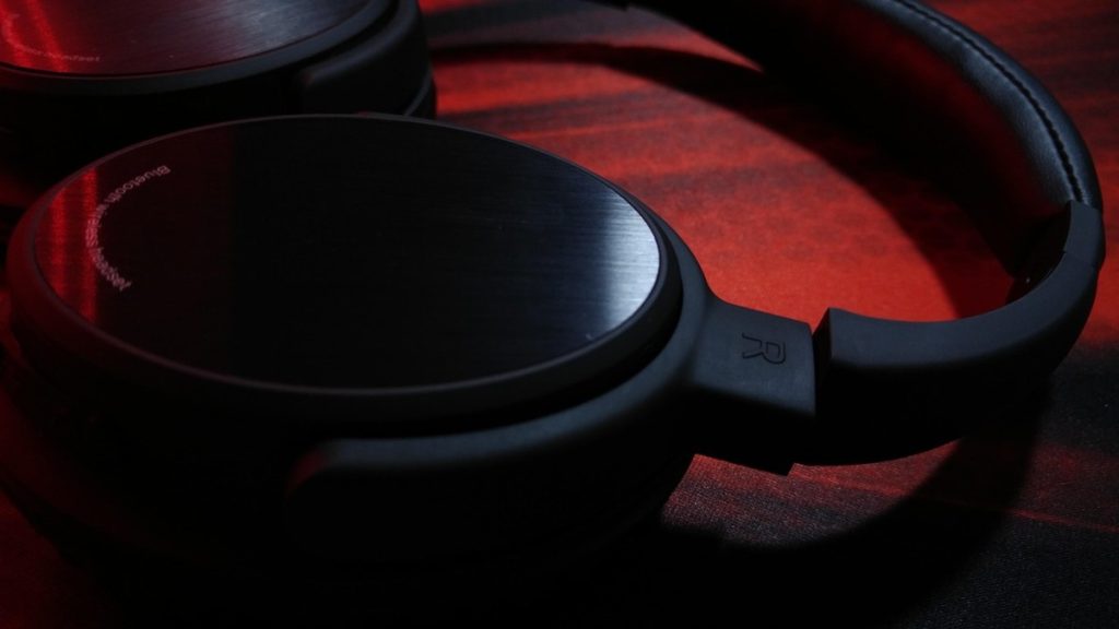 Casque audio noir posé sur surface sombre lumière rouge ambiante