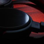 Casque audio noir posé sur surface sombre lumière rouge ambiante