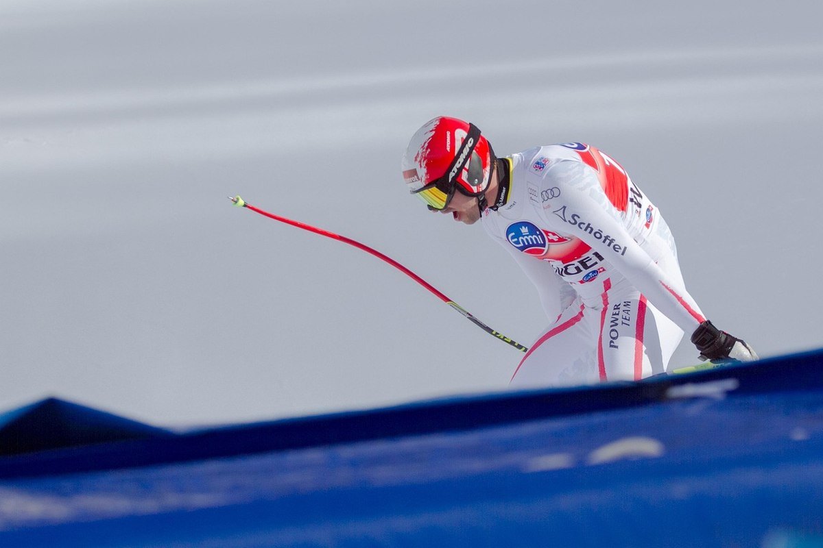 Un pilote en combinaison de ski prêt à monter dans un kart sur la neige