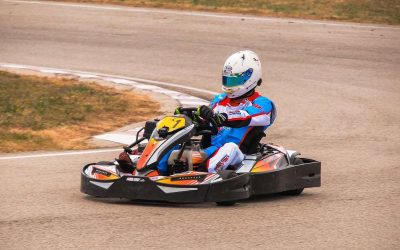 Un pilote en kart coloré tourne sur une piste de ciment