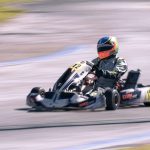 Un pilote en kart de course sur circuit, vitesse ressentie